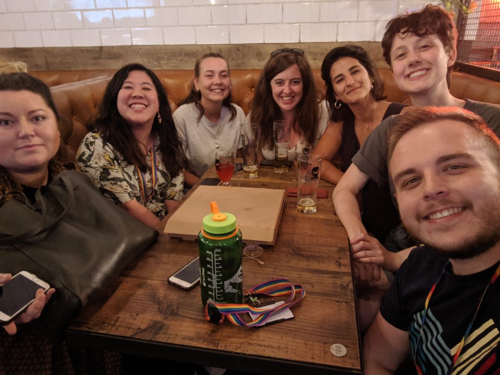 A group of people in a selfie around a table, all smiling at the camera.